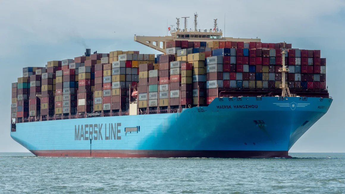 Shipping container ship on water with MAERSK written on side.