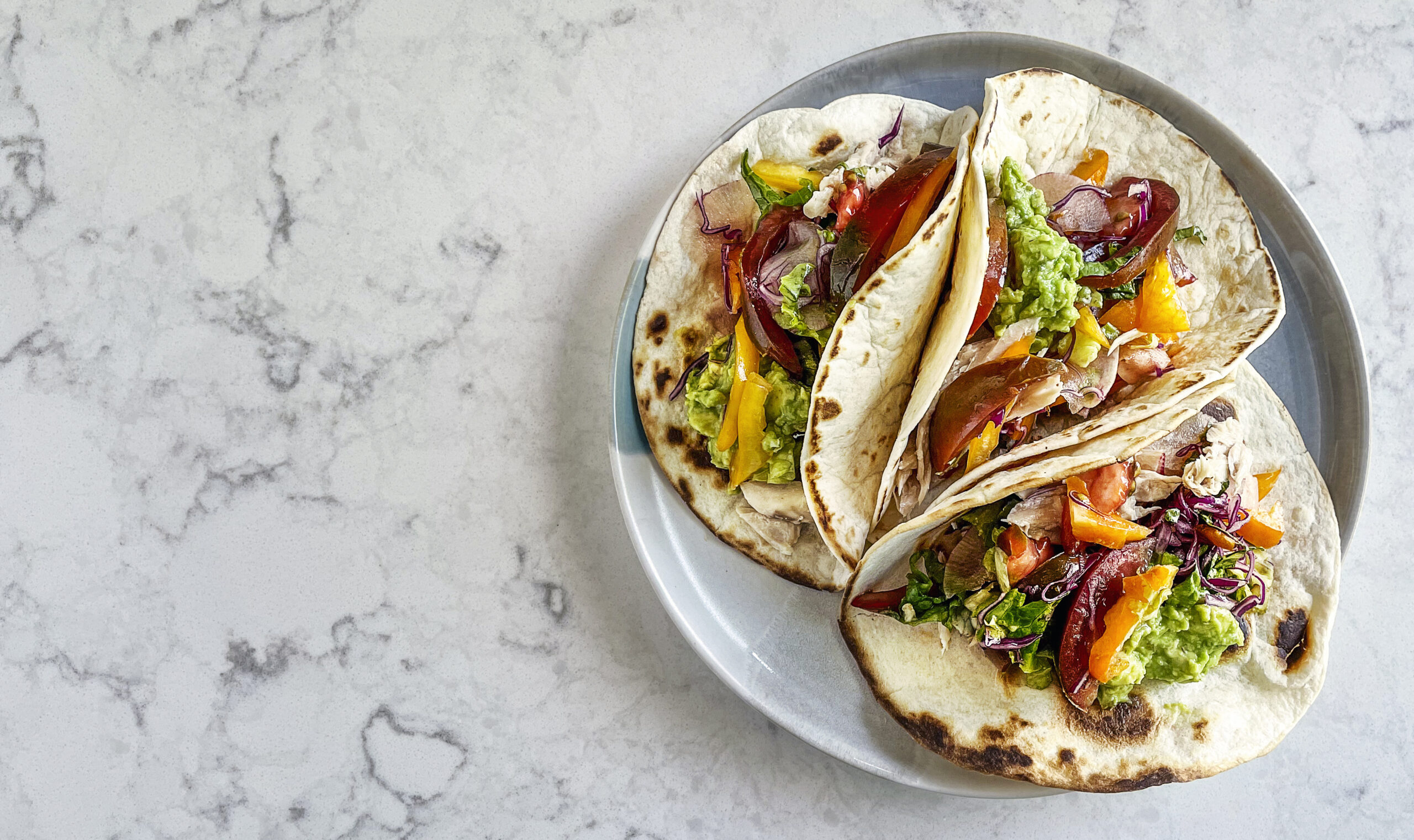 plate of tacos sitting on marble countertop